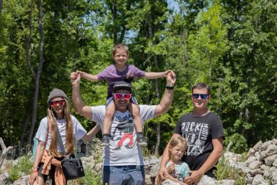 A joyful family enjoying a sunny day outdoors, captured in a lively and happy moment.
