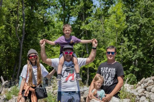A joyful family enjoying a sunny day outdoors, captured in a lively and happy moment.