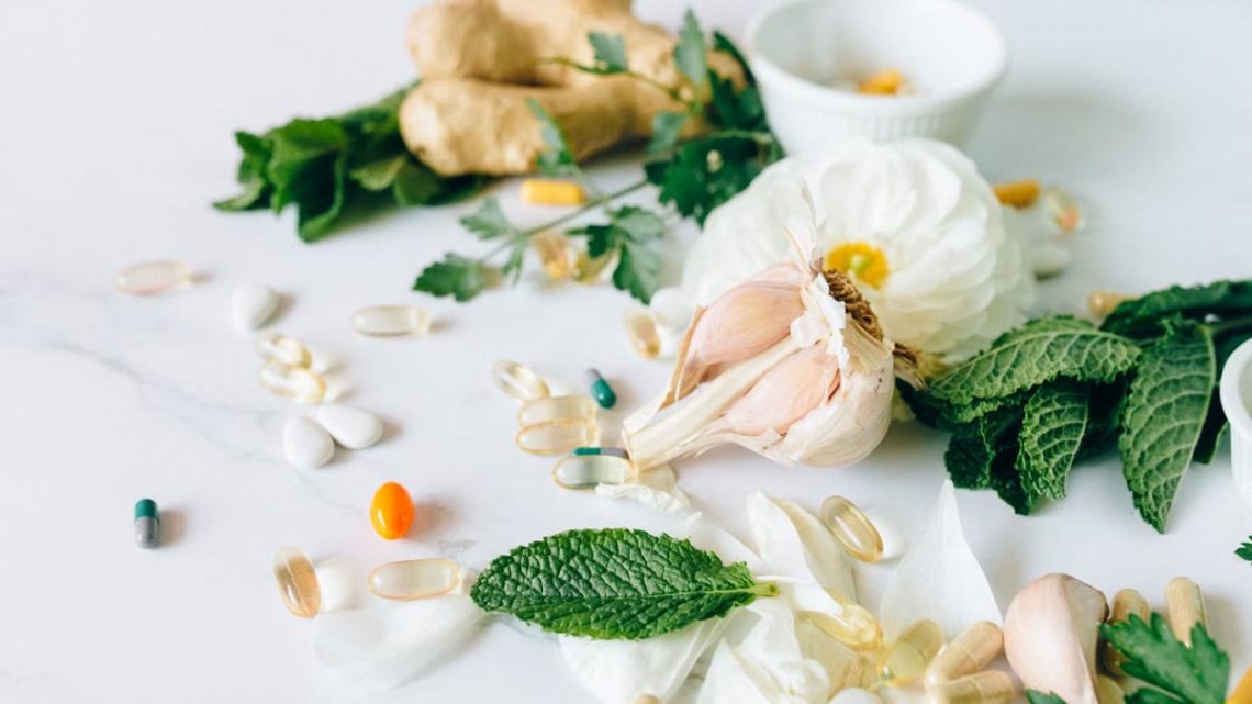 A flat lay of various herbal remedies and vitamin supplements, featuring natural herbs and capsules.