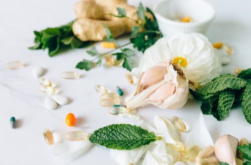 A flat lay of various herbal remedies and vitamin supplements, featuring natural herbs and capsules.