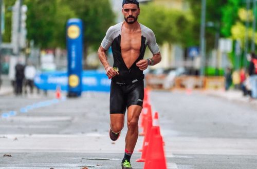 Focused male athlete running a marathon in an urban setting, showcasing endurance and determination.