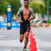 Focused male athlete running a marathon in an urban setting, showcasing endurance and determination.